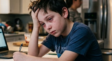 young boy showing extreme signs of distress with red eyes and hand on head